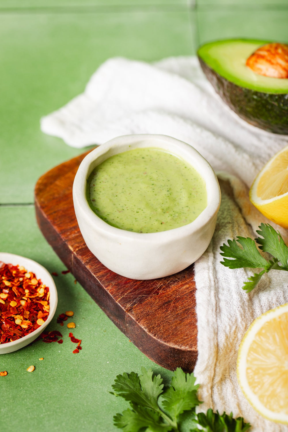 Avocado oil dressing being poured over a freshly prepared salad